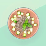 Banner van een Luxe Keto Chocolade Smoothie met Komkommer en Chiazaad, stijlvol gepresenteerd in een glazen kom tegen een pastelkleurige achtergrond.