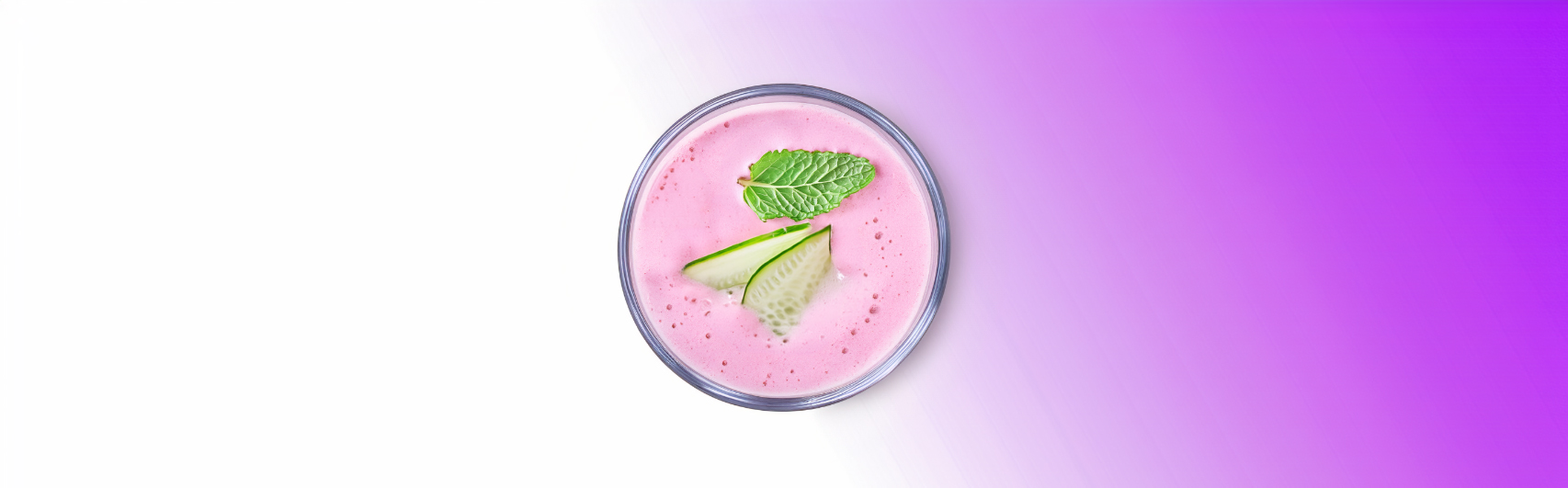 Een verfrissende aardbeien smoothie met avocado en komkommer, geserveerd in een helder glas, mooi gepresenteerd tegen een overgangsachtergrond van lichtroze naar diep paars.